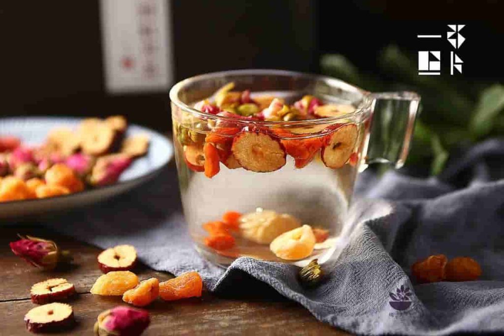 Images of flower tea brewing in a clear glass of water