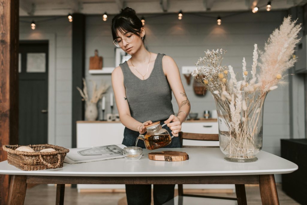 Woman in Gray Tank Top Pouring Tea Images